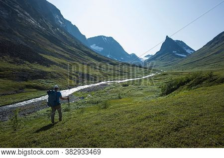 Hiking in Swedish Lapland. Man trekking alone next to Nallo mountain in northern Sweden. Arctic nature of Scandinavia in summer day