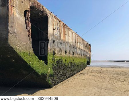 Close Shot Of Massive Concrete Caisson On Omaha Beach, Covered With Algae And Sitting On The Sand On