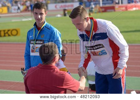 DONETSK, UKRAINE - JULY 12: Medal ceremony in Octathlon boys during 8th IAAF World Youth Championships in Donetsk, Ukraine on July 12, 2013. Ukrainian NOC President S. Bubka (in front) hand off medals