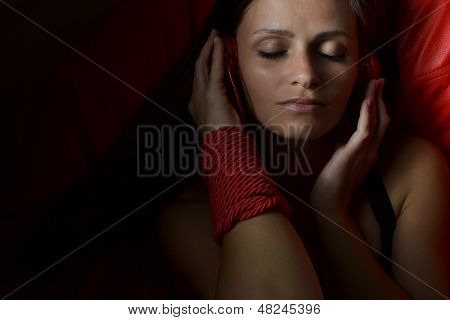 Красивая молодая женщина с красной Наушники