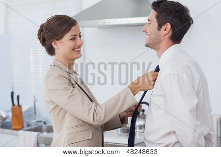 Mulher, ajudando seu marido a gravata dele antes de ir ao trabalho
