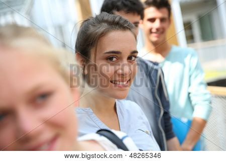Ritratto di sorridente ragazza scuola tra gruppo