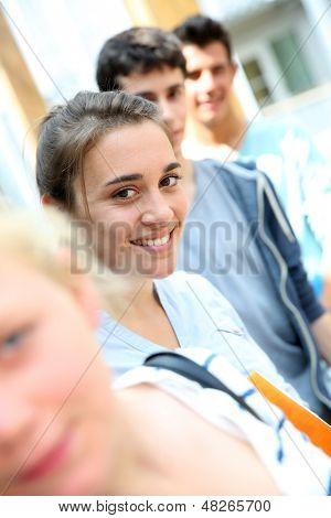 Ritratto di sorridente ragazza scuola tra gruppo