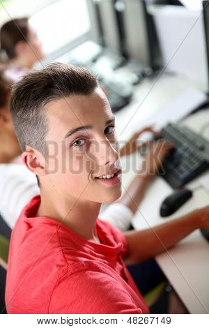 Masaüstü bilgisayar başında oturan yüksek shool çocuk