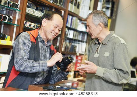 Assistent für die Verkäufer helfen Käufer durch den Nachweis der digitale Fotokamera im Shop speichern