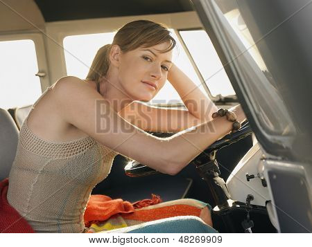 Portrét krásné mladé ženy sedící u řidiče campervan