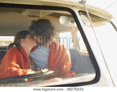 Milující mladý pár líbání v campervan během roadtrip