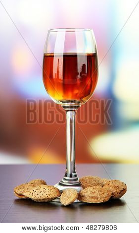 Sklenice likéru amaretto a pražených mandlí, na světlé pozadí