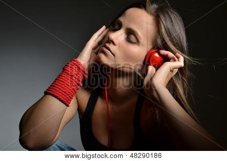 Красивая молодая женщина с красной Наушники