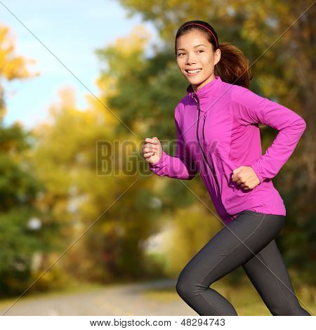 Ung asiatisk kvinna kör kvinnliga jogger glad. Kvinnliga löpare jogging i park i höst park skogen jag