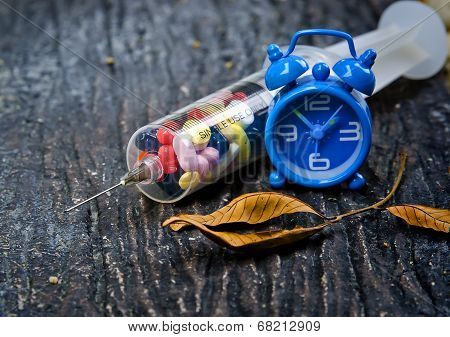 Syringe With Pills And Clock