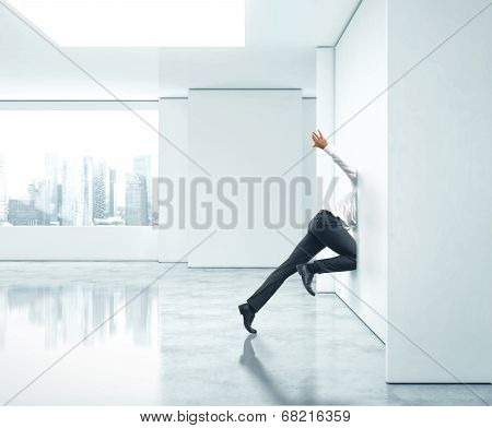 Businessman getting stuck into office wall
