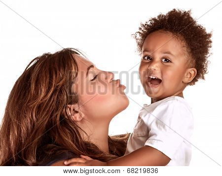 Closeup portrait of African family having fun in the studio, cheerful mother try to kiss her cute little son, happy childhood concept 