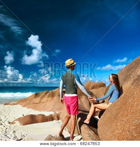 Couple on a tropical beach at Seychelles wearing rash guard