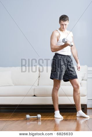 Uomo utilizzando pesi del braccio In salotto