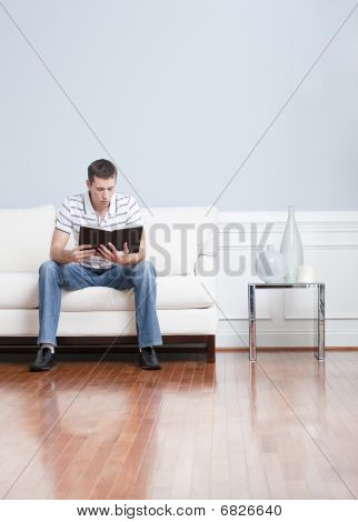 Uomo lettura sul divano del salotto