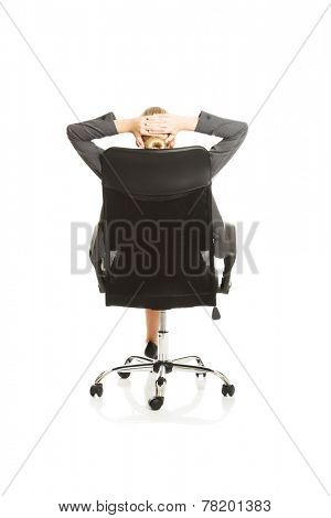 Businesswoman resting on armchair holding her neck