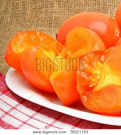 Ripe Persimmon Fruits On White Plate And Napking, Sacking Background