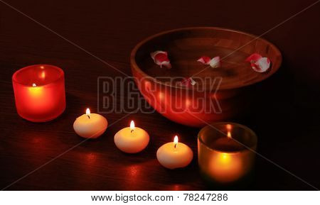 Glass Candlesticks And Candles And Wooden Bowl Of Water With Petals