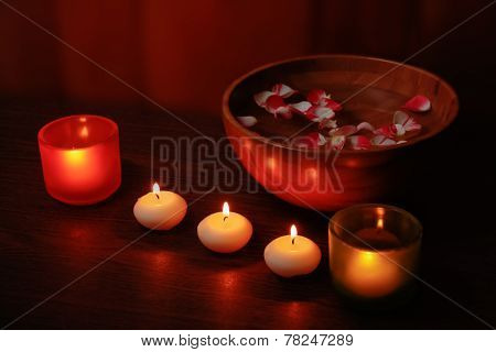 Glass Candlesticks And Candles And Wooden Bowl Of Water With Petals