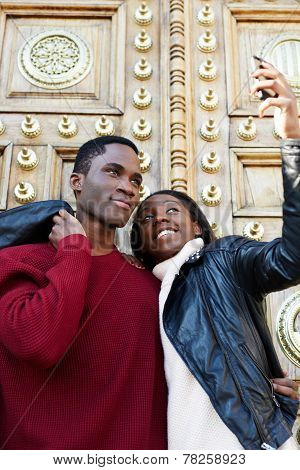 Dating couple happy in love taking self-portrait photo on beautiful antique door background