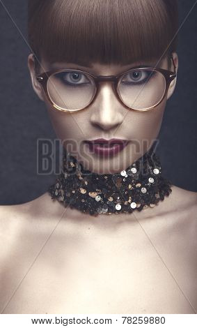 Graceful lady in eyeglases with red lips ,brown forelock and sequin necklace.
