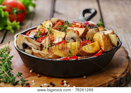 Fried potatoes with mushrooms in a frying pan