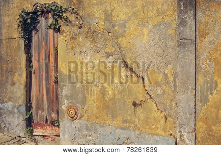 Old wooden door on the yellow wall.