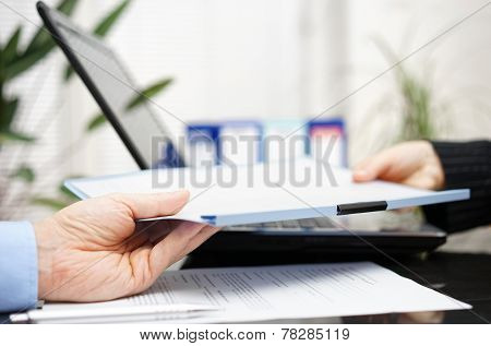 Businessman And Businesswoman Are Exchanging Document Or Contract