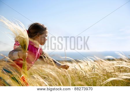 Cute Little Girl Picking Grasses