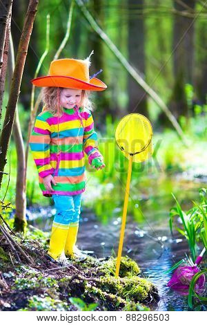 Little Girl Playing Outdoors Catching A Frog