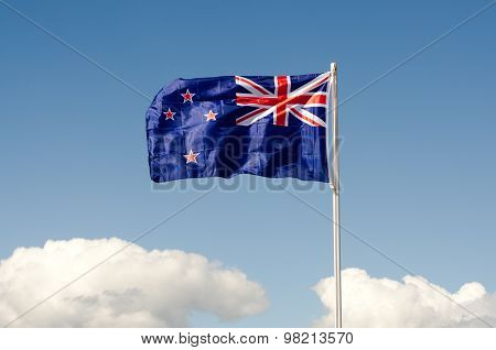 New Zealand National flag wave above long white clouds.