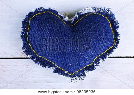 Denim heart on wooden background