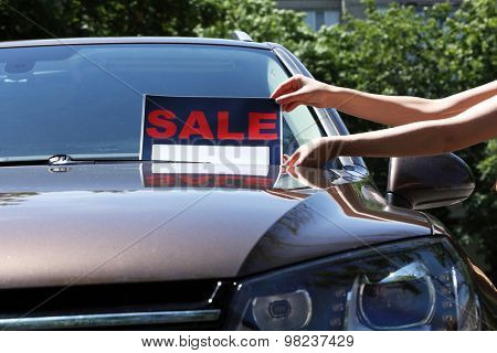 For sale sign on windshield of car.