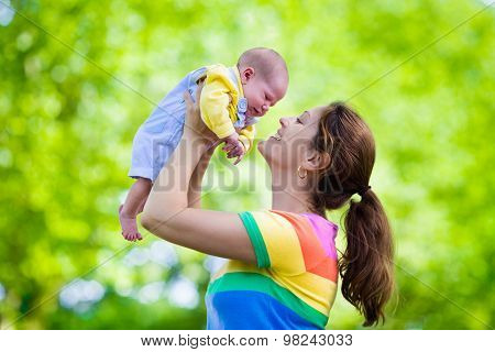 Mother Holding Newborn Baby In A Park