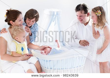 Happy Family Watching New Baby In A White Crib