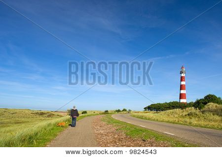 Uomo sta camminando nel paesaggio con faro