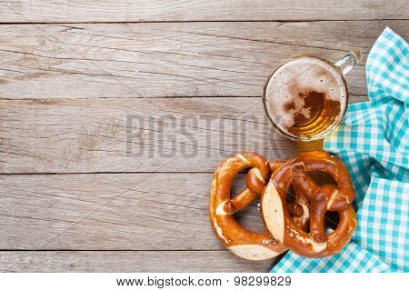Beer mug and pretzel on wooden table. Top view with copy space
