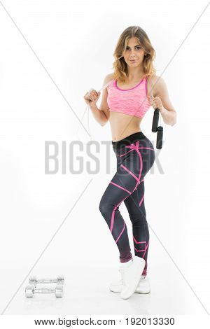 Young atletic woman with jumping rope. Attractive girl.