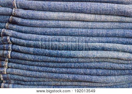 A few folded jeans. Jeans stacked on top of each other