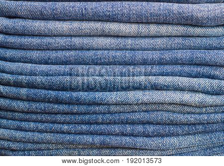 A few folded jeans. Jeans stacked on top of each other