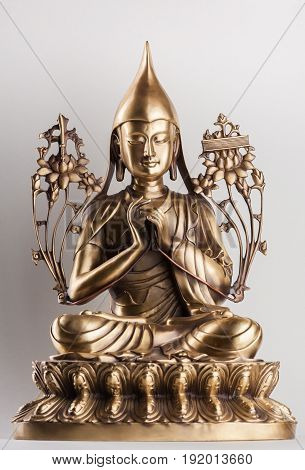 Bodhisattva Avalokiteshvara - a figure from bronze sitting on a white background in a pose of a lotus a hands in Dkharmachakra-mudra.