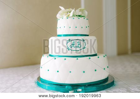 A multi-level white maroon wedding cake with white lilies on top