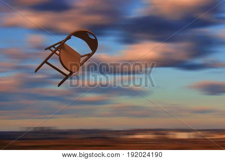 Chair flying in the sky. Brown - orange chair motion on blurred background. Yellow pink clowds. Concept: speed-up, velocity