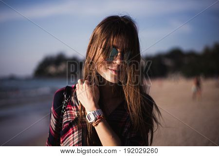young stylish happy hipster woman traveling around the world wearing aviator sunglasses, denim shirt, tropical island lagoon vacation.