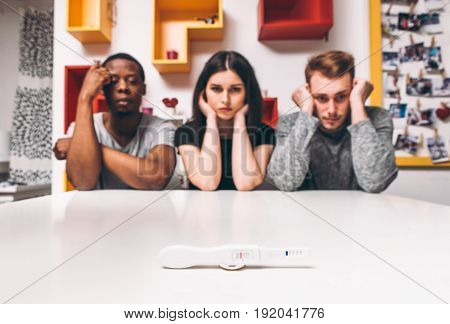 Negative pregnancy test result, disappointment. Woman with two man, polygamy group. 
