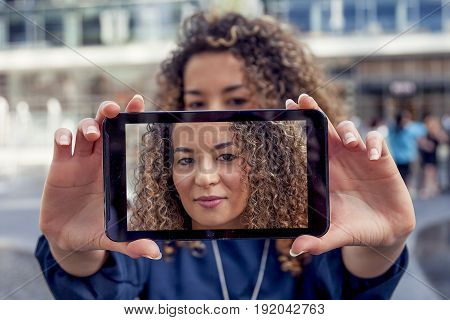 pretty young woman take a selfie with smart phone in the heart of a capital city