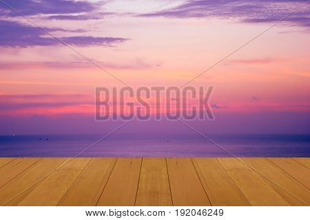 wood floor on sea with purple sunset Burning Skie beautiful natural tropical sea