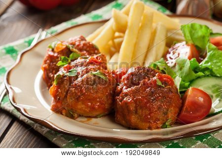 Roasted Meatballs In Tomato Sauce With French Fries And Salad