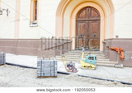 Vibration plate compactor is at construction site in the city street.